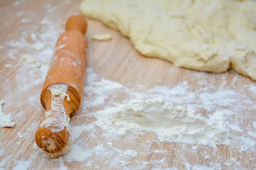 Rolling pin in the dough close-up, gluten-free flour and dough. Cooking healthy diet baking at home.