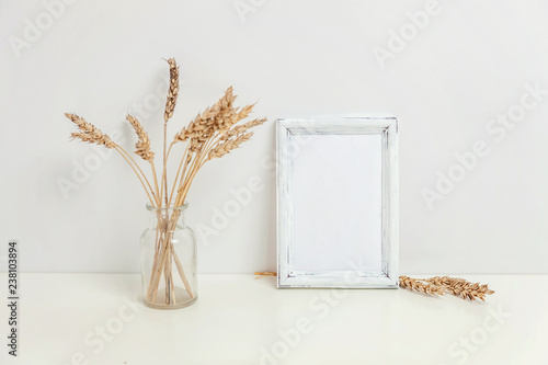 Vertical Frame Mockup With Wild Rye Bouquet In Glass Vase Near White Wall Empty Frame Mock