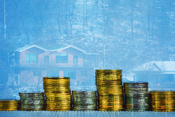 Double exposure of coin stack with financial graph over city and office building background, business and financial concept.