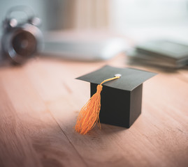 Construction paper craft graduation hat on wood desk