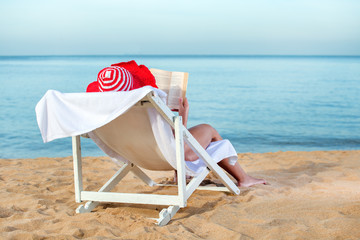 Wall Mural - Woman Reading A Book At Beach. Vacation, holiday concept.