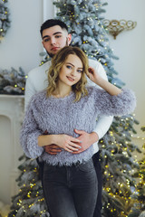 Wall Mural - Couple in love: a guy and a girl on the background of the Christmas tree? Christmas background