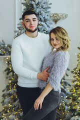 Wall Mural - Couple in love: a guy and a girl on the background of the Christmas tree? Christmas background