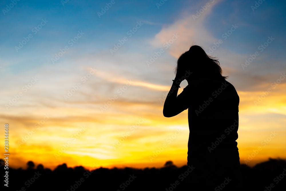 Silhouette woman standing sad in the sunset. Stock Photo | Adobe Stock