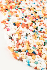 High number of pills on white background surface. High resolution image for pharmaceutical industry.