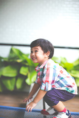 outdoor portrait of a cute little asian boy smiling in the park