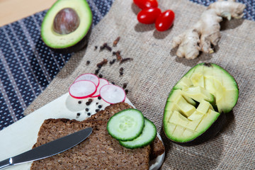 Healthy food flat and stylishly laid out on the table. Bread with avocado and greens