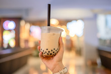 Woman Hand Holding Iced Milk Bubble Tea With Tapioca Pearls, Traditional Drink Of Taiwan