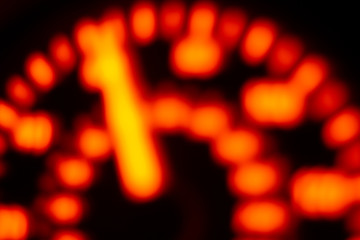 Wall Mural - A Defocussed car speedometer lit up by orange light at night