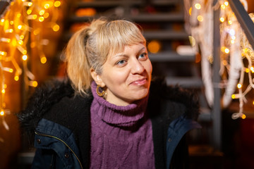 Wall Mural - Portrait of woman sitting on stairs at Christmas market.