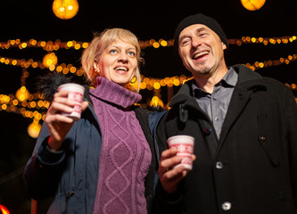 Wall Mural - Couple talking at Christmas market. Zagreb, Croatia.