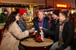 © paul prescott - Group of friends cheering with traditional drink at Christmas market.