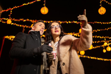 Wall Mural - Couple pointing to decoration at Christmas market. Zagreb, Croatia.