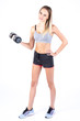 © dima - Beautiful young slim girl with dumbbells on a white background. Novice athlete