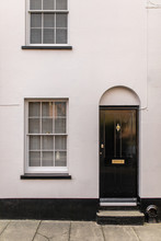 Black And White Typical English House Facade With Door And Window Viewed From Outdoors.