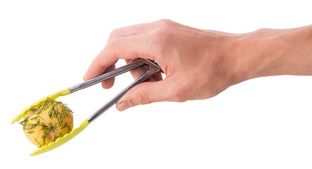 Wall Mural - The hand holds kitchen tongs in which the young boiled potatoes in dill