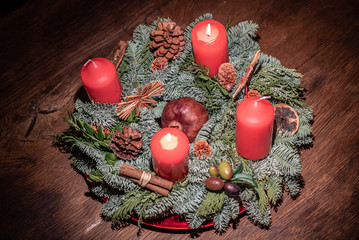 advent wreath and two burning red candles on a wooden table Studio