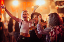 Female Friends Cheering With Beer At Music Festival