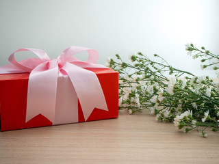 Red gift box tied with pink ribbon