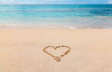 A Heart Drawn In The White Sand Of A Caribbean Beach, With Turquoise Blue Ocean In The Background.