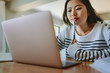 © Jacob Lund - Asian woman studying at home using laptop