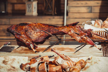 Whole grilled lamb on cutting board. Hot Meat dishes