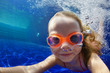 Happy family in swimming pool. Smiling child in goggles swim, dive in pool with fun - jump deep down underwater. Healthy lifestyle, people water sport activity, swimming lessons on holidays with kids