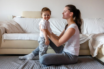 Wall Mural - Cute small boy with Down syndrome playing with mother in home