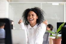 Excited African American woman receiving good news in email on laptop, motivated black female employee getting promoted, celebrating business achievement, reward, great results, win, opportunity