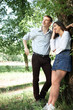 © soleg - young couple walking in the forest, posing near tree, summer nature, bright sunlight, shadows and green leaves, romantic feelings