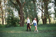© soleg - young couple walking in the forest and playing guitar, summer nature, bright sunlight, shadows and green leaves, romantic feelings
