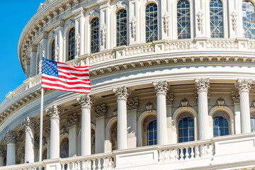 US Congress dome closeup with American flag waving in Washington DC, USA on Capital capitol hill, blue sky, columns, pillars, nobody