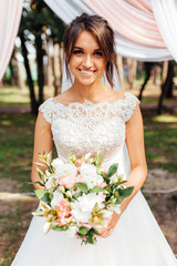 Wall Mural - portrait of a beautiful bride in nature, in a white dress