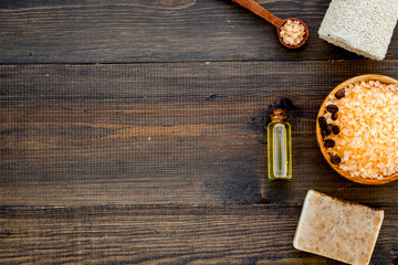 Aromatherapy and spa concept. Spa salt with coffee scent near soap and loofah on dark wooden background top view copy space