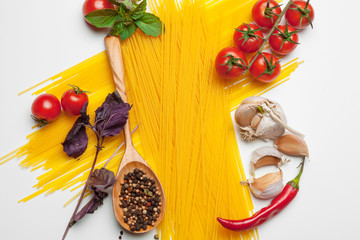 Pasta Spaghetti with ingredients for cooking pasta on a white background, top view.