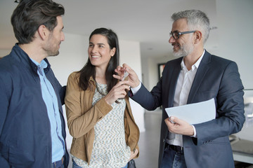 Wall Mural -  Real-estate agent handing over keys to new home owners in contemporary house