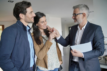 Wall Mural -  Real-estate agent handing over keys to new home owners in contemporary house