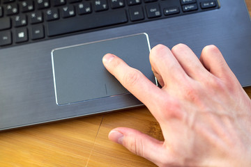 male index finger on a laptop trackpad