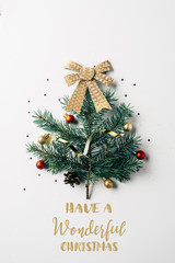 Wall Mural - top view of green pine branch decorated as festive christmas tree with bow on white background with 