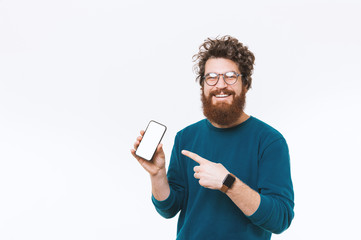 Wall Mural - Portrait of happy bearded man pointing at blank screen on smartphone