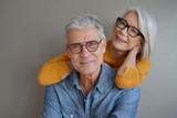 Fototapeta  -  Portrait of relaxed fun senior couple wearing glasses on background