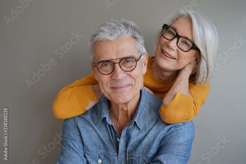 Cuadros en Lienzo Portrait of relaxed fun senior couple wearing glasses on background