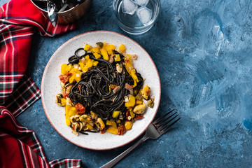 Wall Mural - Black pasta with seafood, anchovies, tomatoes and bell peppers.