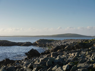 Wall Mural - sunset over the sea with rocky coastline and islands on the horizon