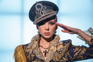 Fashionable woman in military uniform saluting