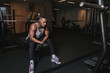 © ADDICTIVE STOCK - Black man in earphones sitting on exercise machine