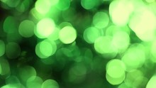 Shiny Unfocused Green Lights. Beautiful Holiday Christmas Abstract Background With Motion Of Round Shiny Particles Isolated On Black Background.
