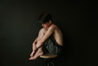© Cavan Images - Side view of shirtless boy sitting on stool