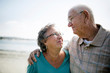 © Cavan Images - Smiling senior couple standing on beach