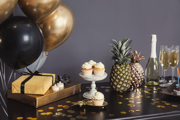 Party treats and items on table in room decorated with balloons